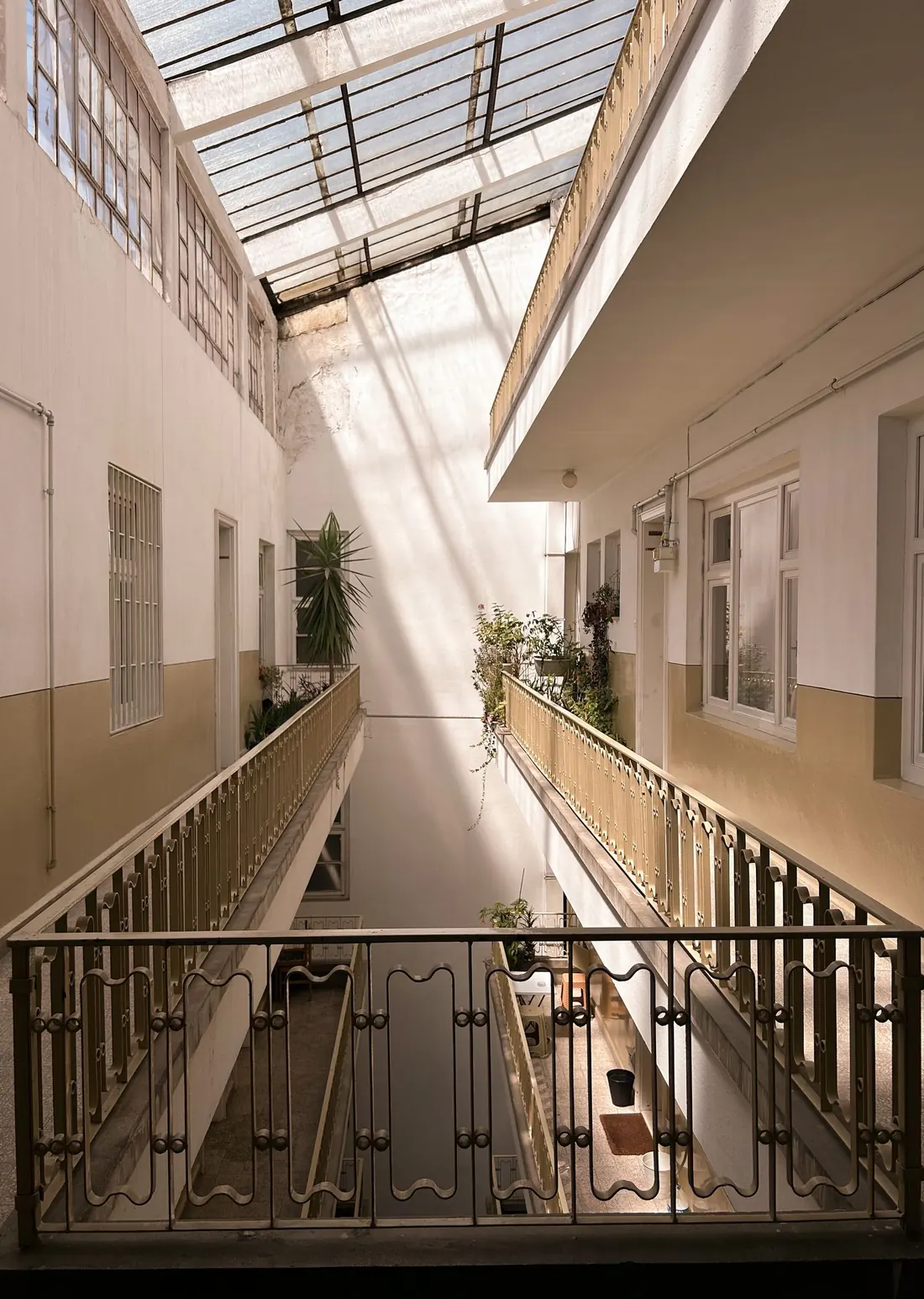 Open breezeway and stair run of a condo building on a bright morning